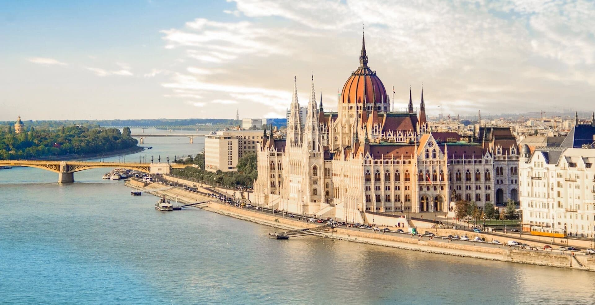 The Hungarian Parliament Building in Budapest, Hungary along the Danube river with a bridge nearby