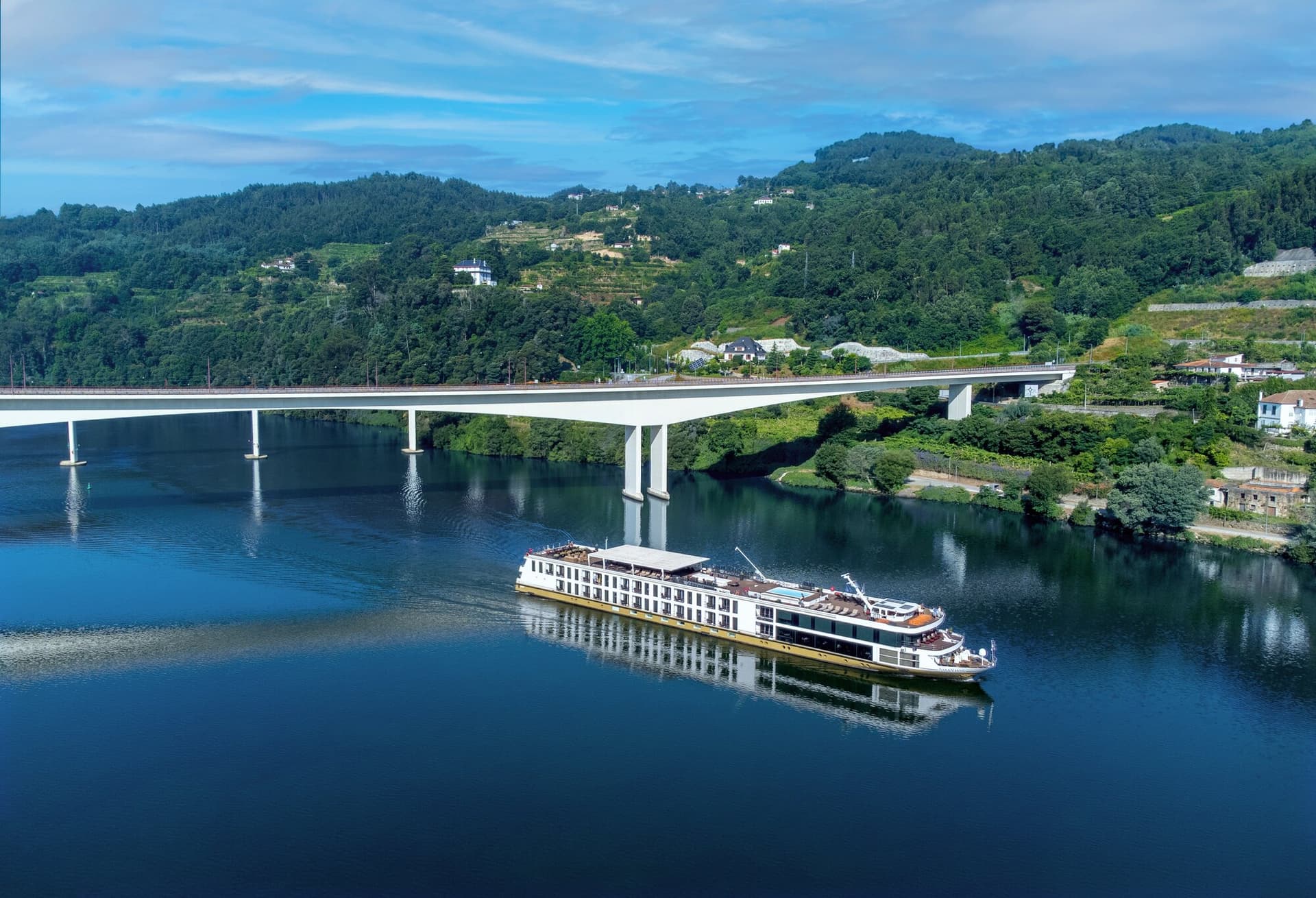 AmaVida cruising beneath a bridge surrounded by vineyards in the Douro Valley, Portugal